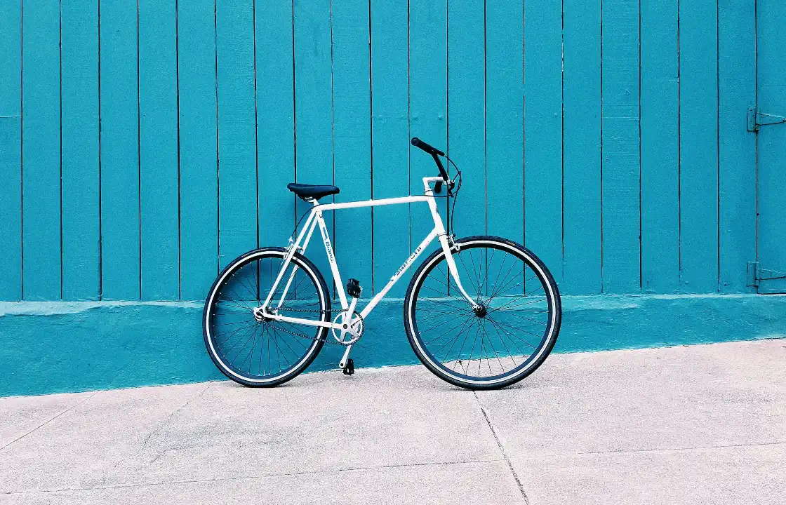 White bicycle in front of a blue wall