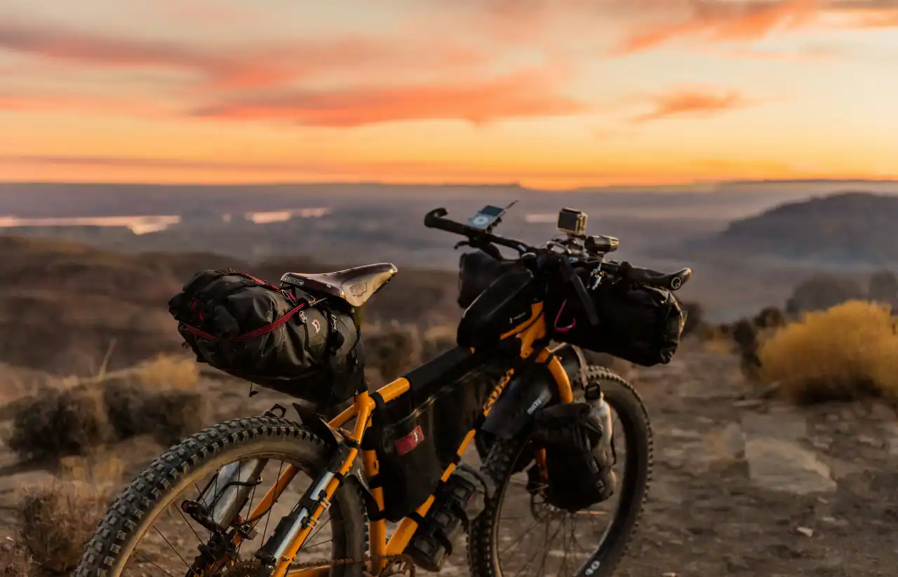 Yellow mountain bike loaded up with gear, overlooking a scenic landscape